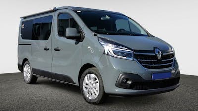 Ein grauer Mooveo Camper Van steht vor einer weißen Wand.
