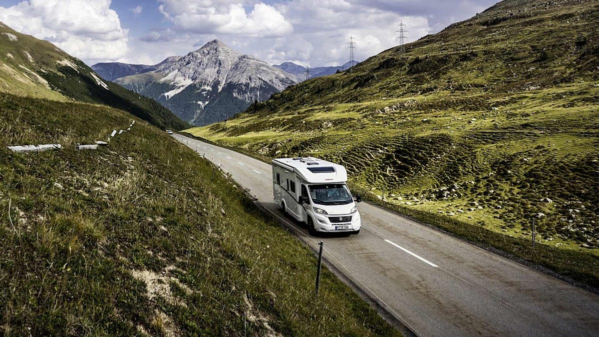 Ein Dethleffs Just 90T Wohnmobil fährt eine Landstraße entlang.