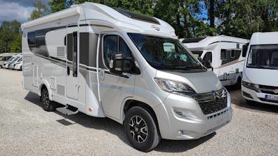 Ein teilintegriertes Wohnmobil Carado T338 steht auf einem Parkplatz.