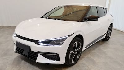 Ein weißer Kia EV6 steht in einem Raum mit hellgrauem Boden und weißen Wänden.