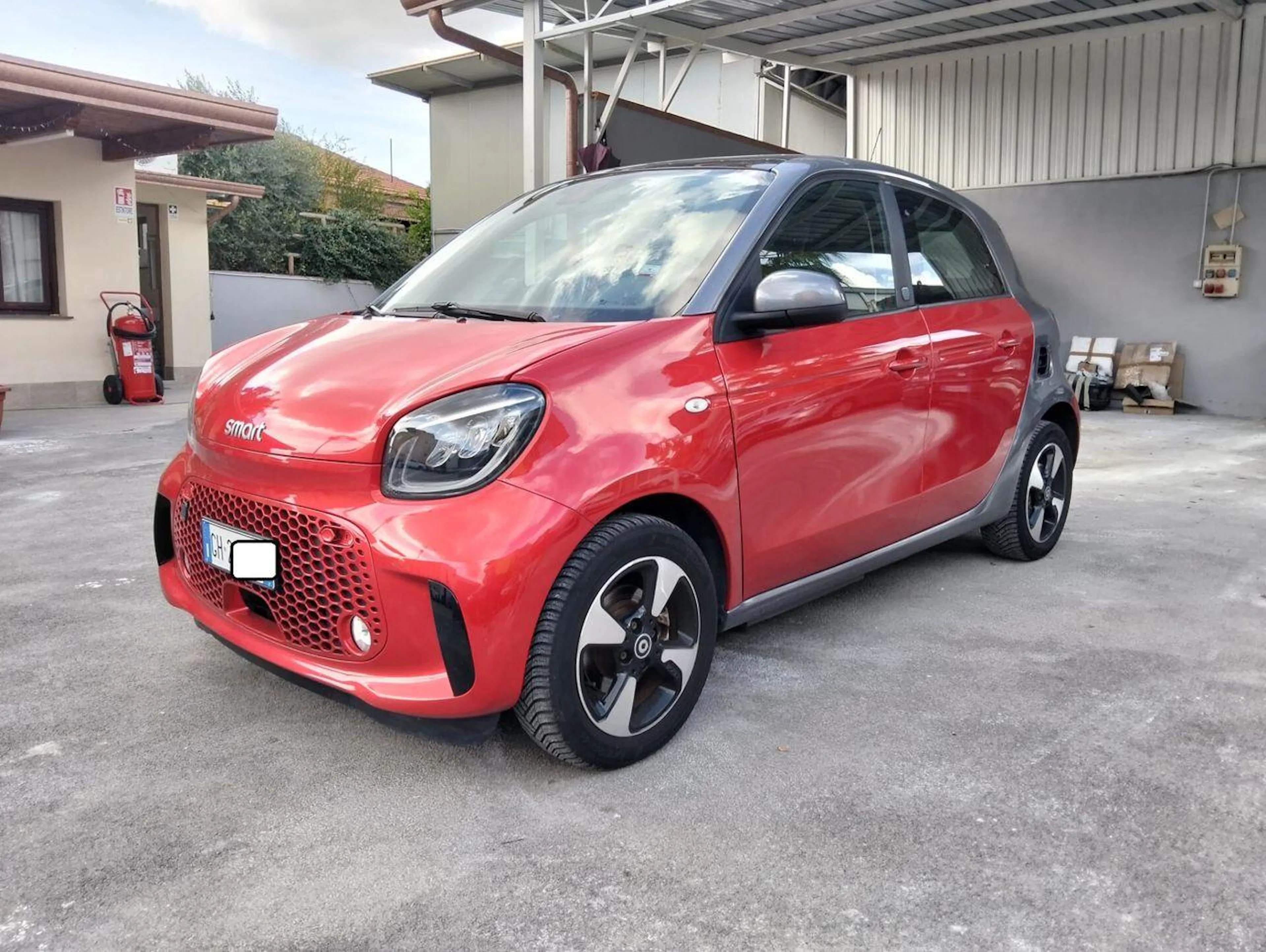 Roter Smart ForFour EQ steht auf einer gepflasterten Fläche.
