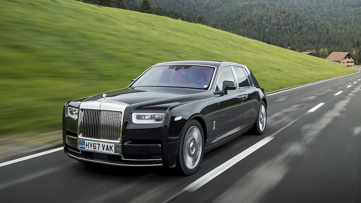 Ein schwarzer Rolls-Royce Phantom fährt eine Landstraße entlang.