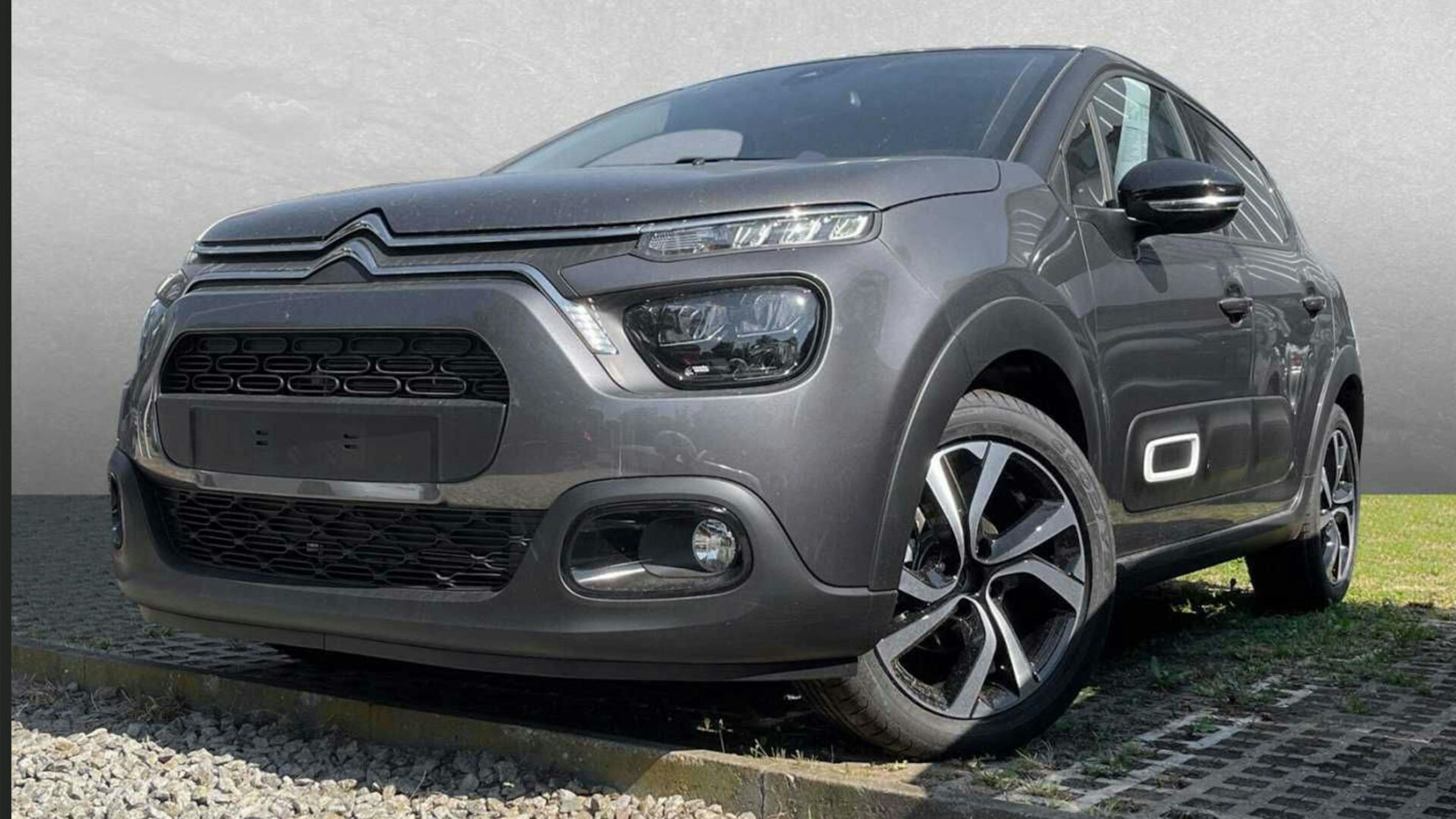 Ein grauer Citroën C3 steht vor einer grauen Wand.