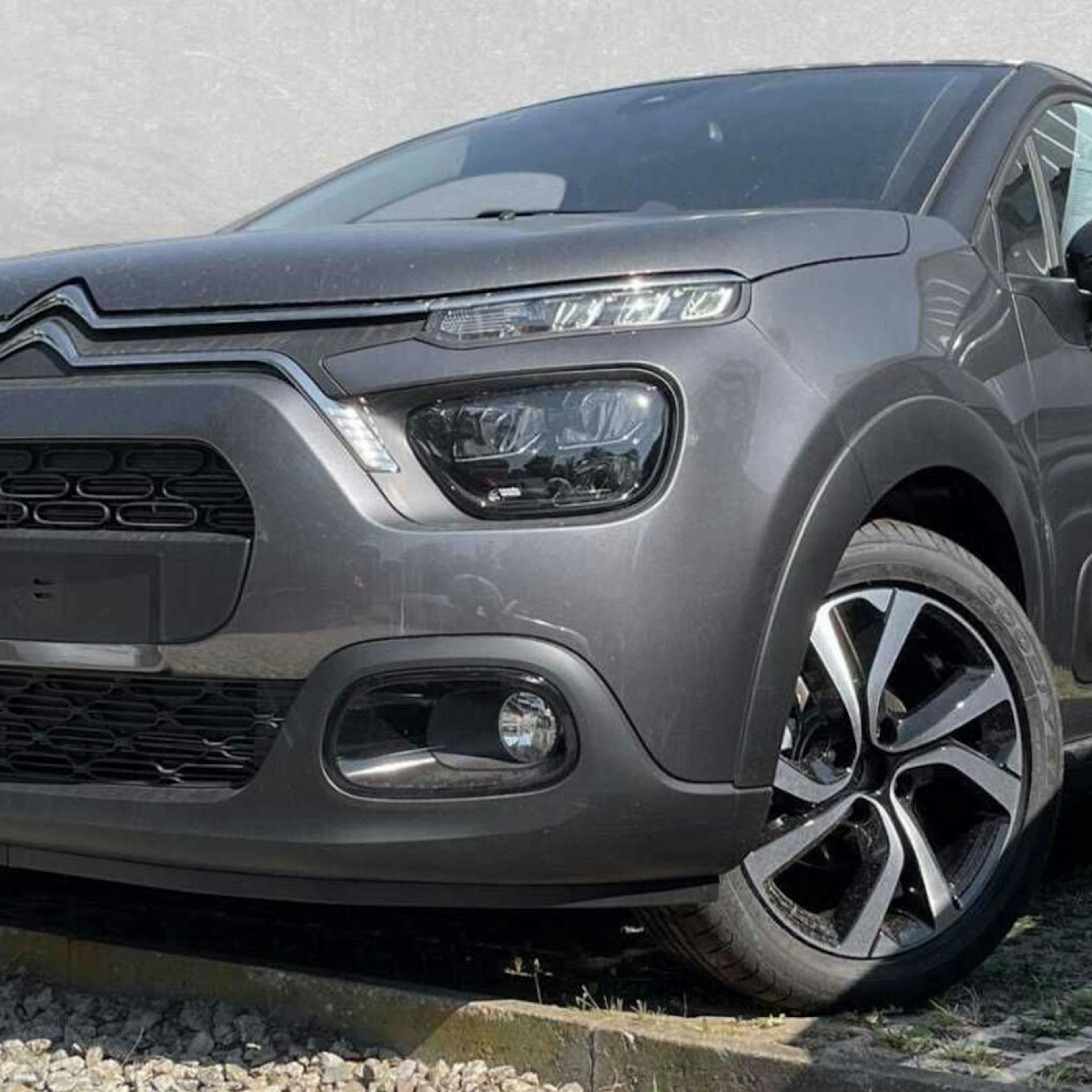 Ein grauer Citroën C3 steht vor einer grauen Wand.