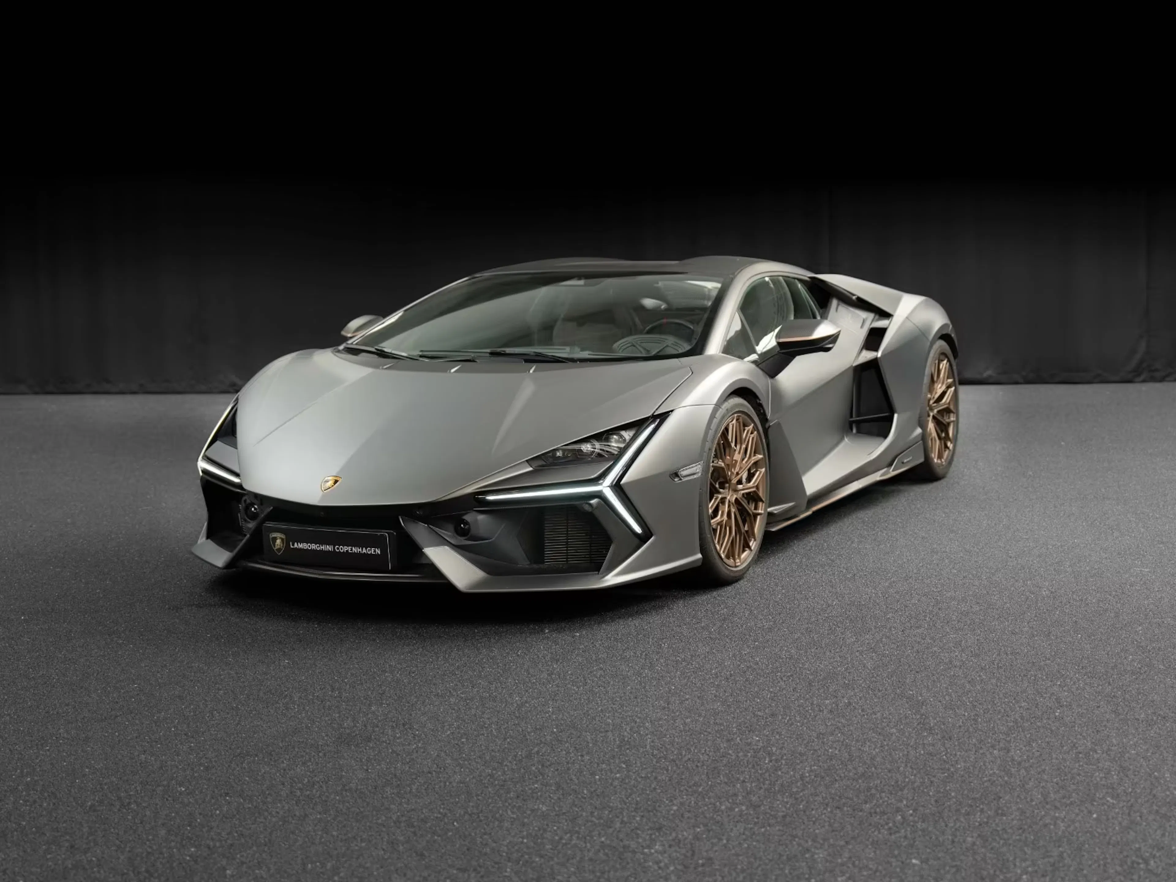 Silberner Lamborghini Revuelto vor schwarzer Wand