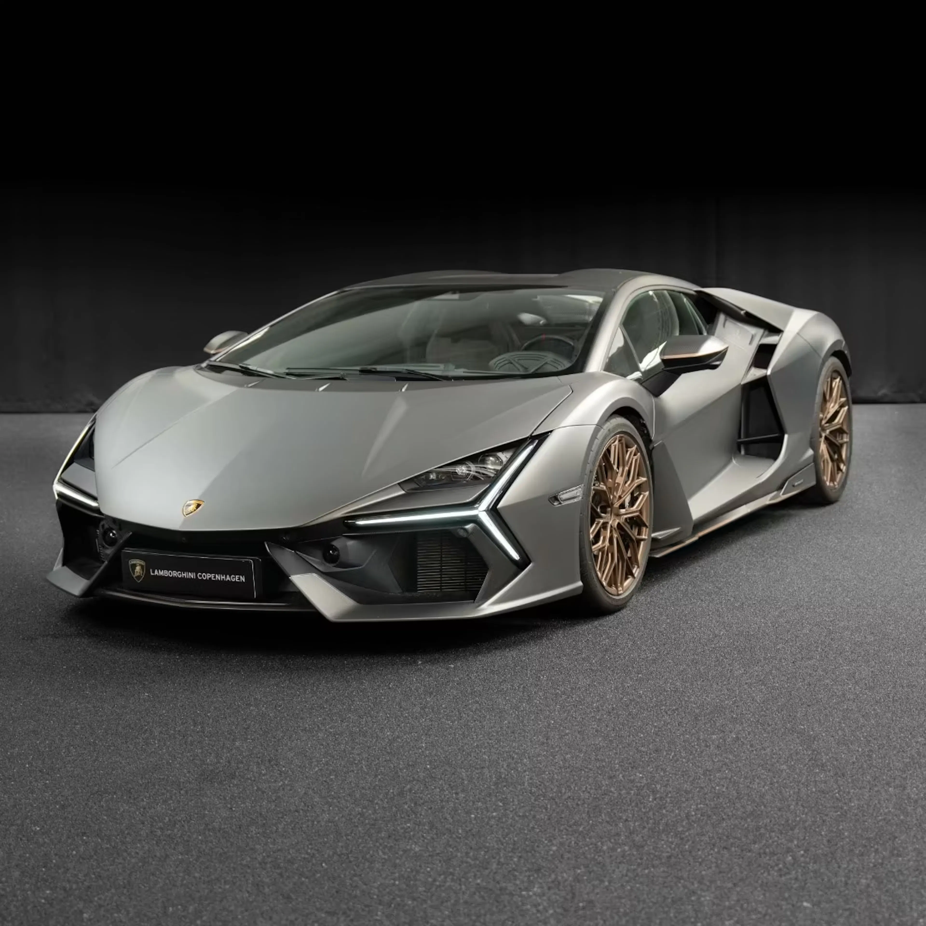 Silberner Lamborghini Revuelto vor schwarzer Wand