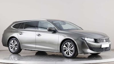 Ein silberner Peugeot 508 SW Plug-in-Hybrid steht in einem weißen Raum