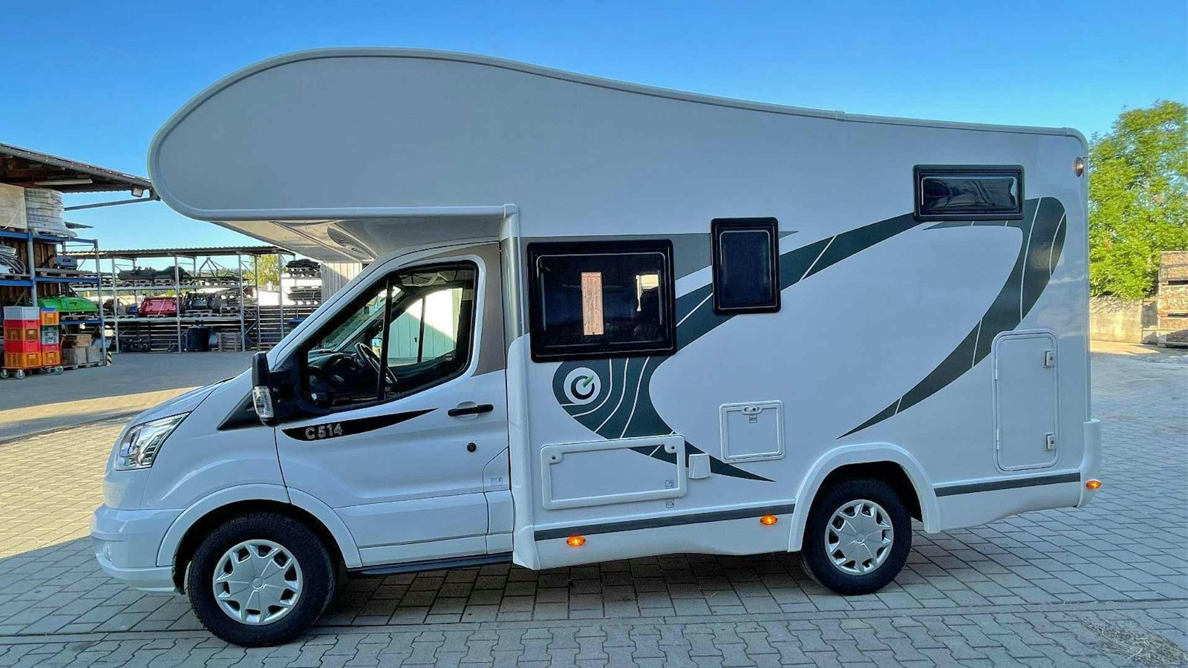 Ein Chausson 514 Wohnmobil mit Alkoven steht auf einem Parkplatz.