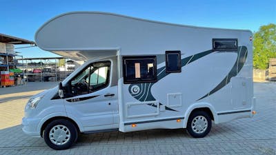 Ein Chausson 514 Wohnmobil mit Alkoven steht auf einem Parkplatz.
