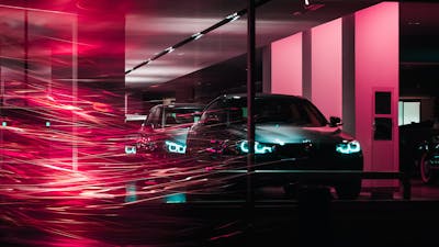Blick durch ein Fenster in die Verkaufsfläche eines Autohauses bei Nacht