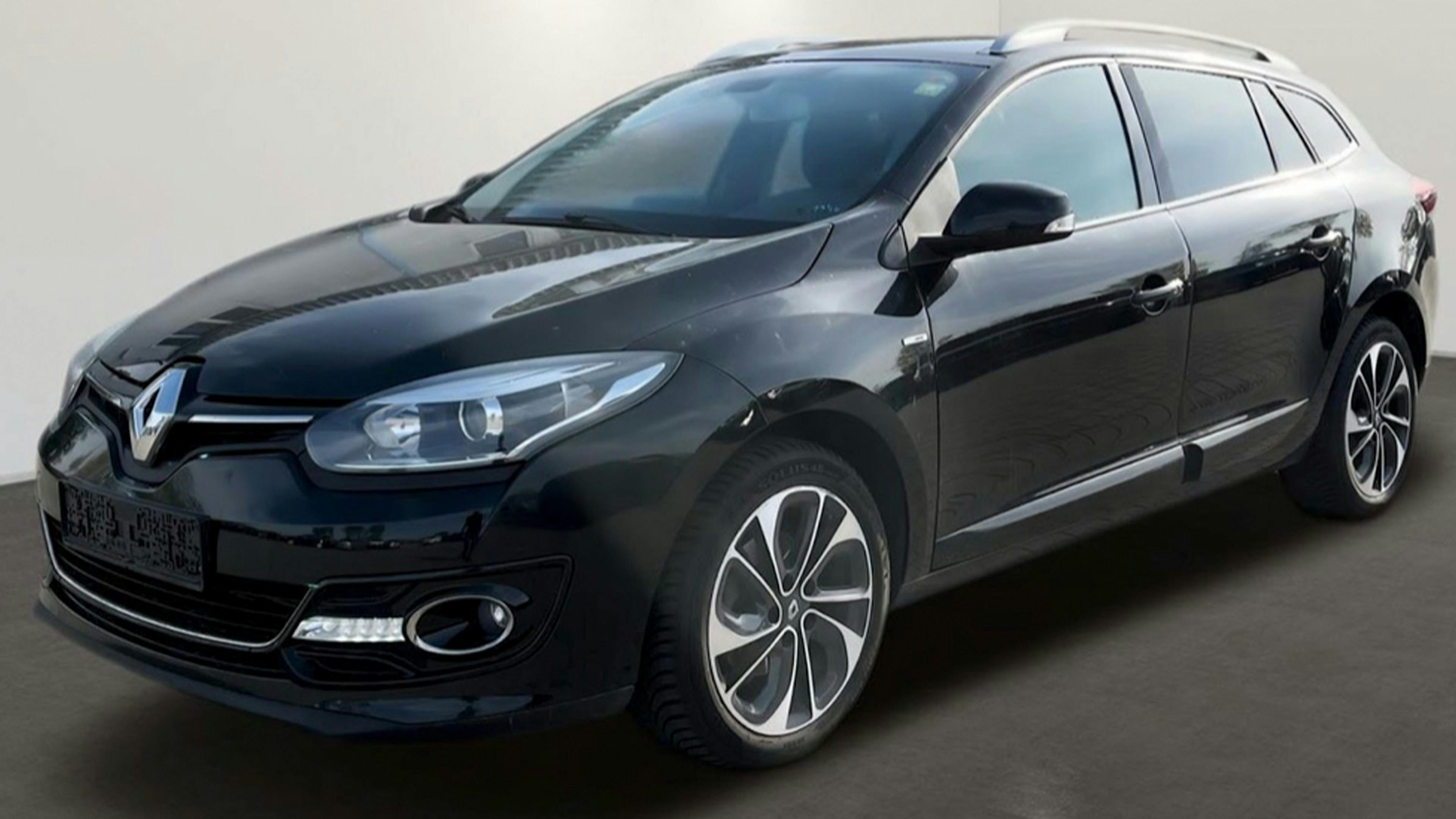 Ein schwarzer Renault Mégane Grandtour Kombi steht vor einer weißen Wand.