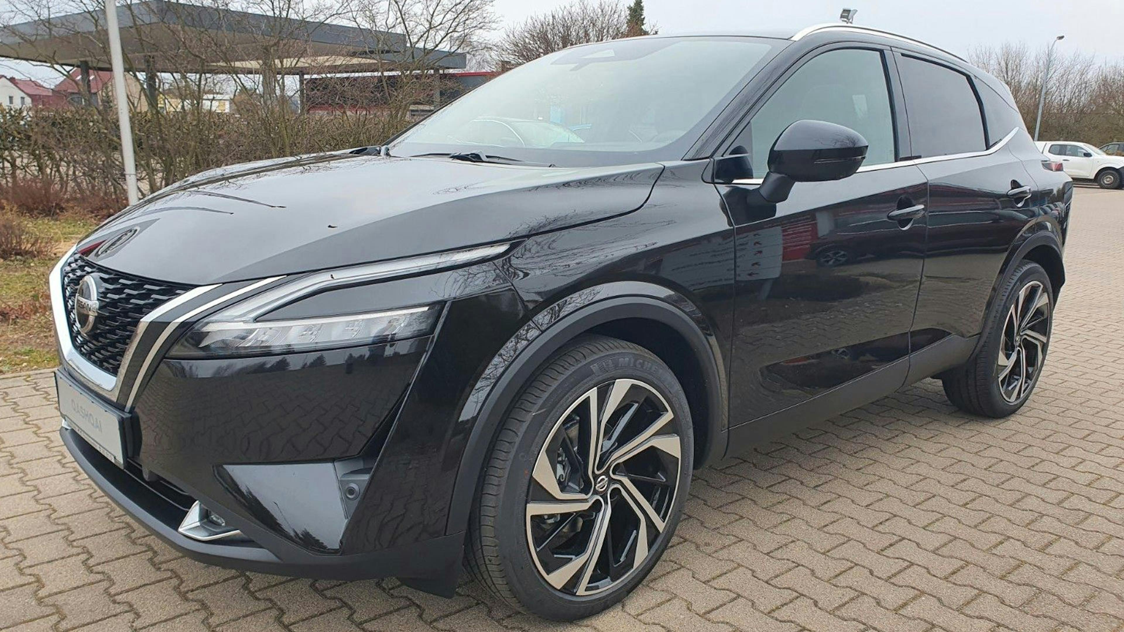 Ein schwarzer Nissan Qashqai steht auf einem Parkplatz. 