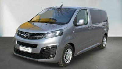 Ein silberner Opel Zafira-e Life steht vor einer weißen Wand.