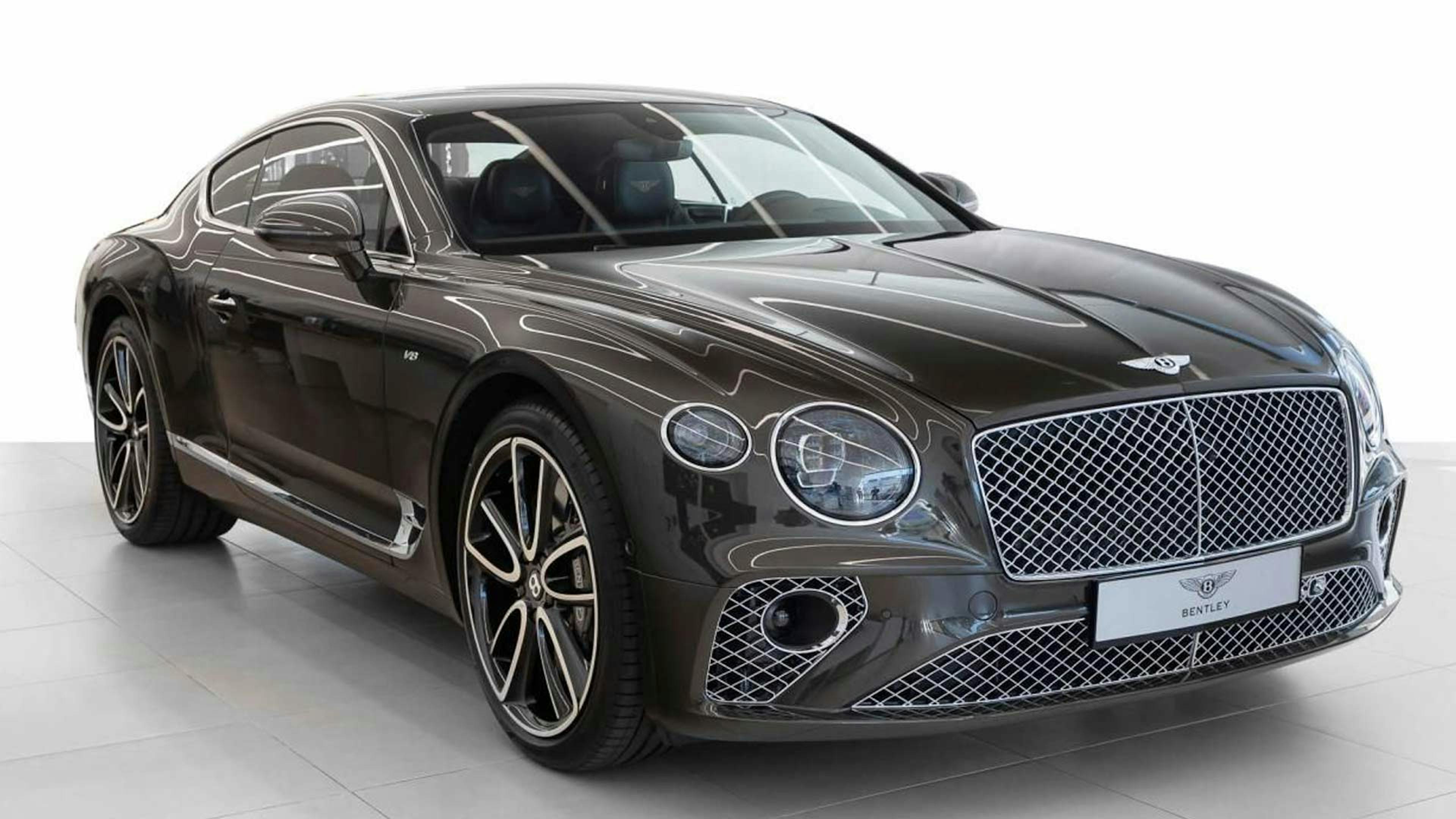 Ein schwarzer Bentley Continental GT steht in einem hellen Raum.