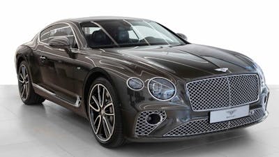 Ein schwarzer Bentley Continental GT steht in einem hellen Raum.