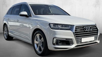 Ein grauer Audi Q7 3.0 TDI e-tron Diesel-Hybrid steht vor einer weißen Wand