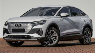 Ein silberner Audi e-tron quattro steht vor einer weißen Wand