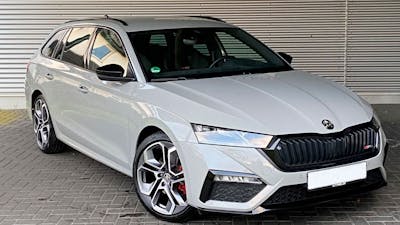 Ein weißer Škoda Octavia steht vor einem grauen Rolltor.