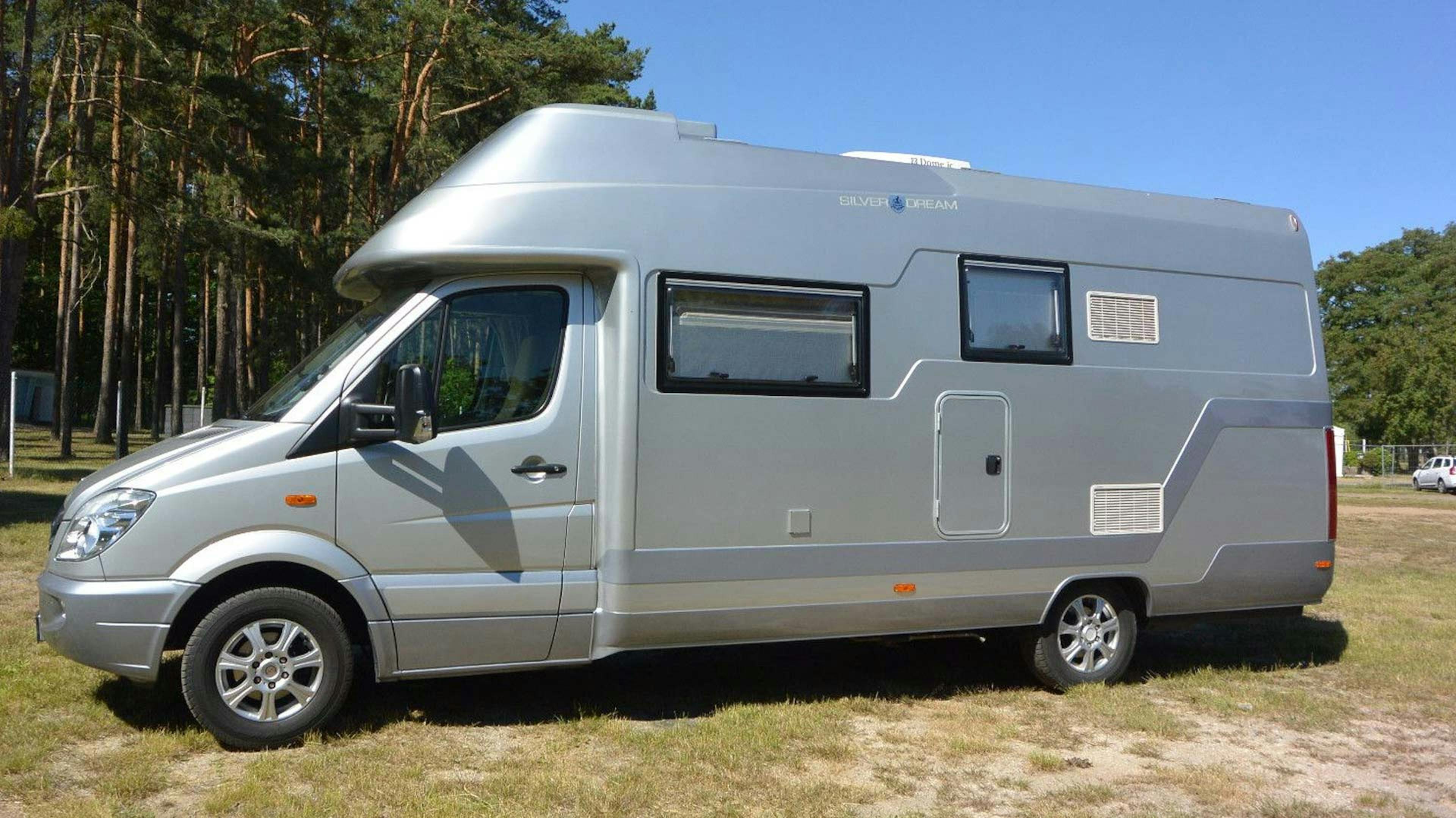 Ein Wanner Silvedream Wohnmobil mit Alkoven steht auf einem Campingplatz.