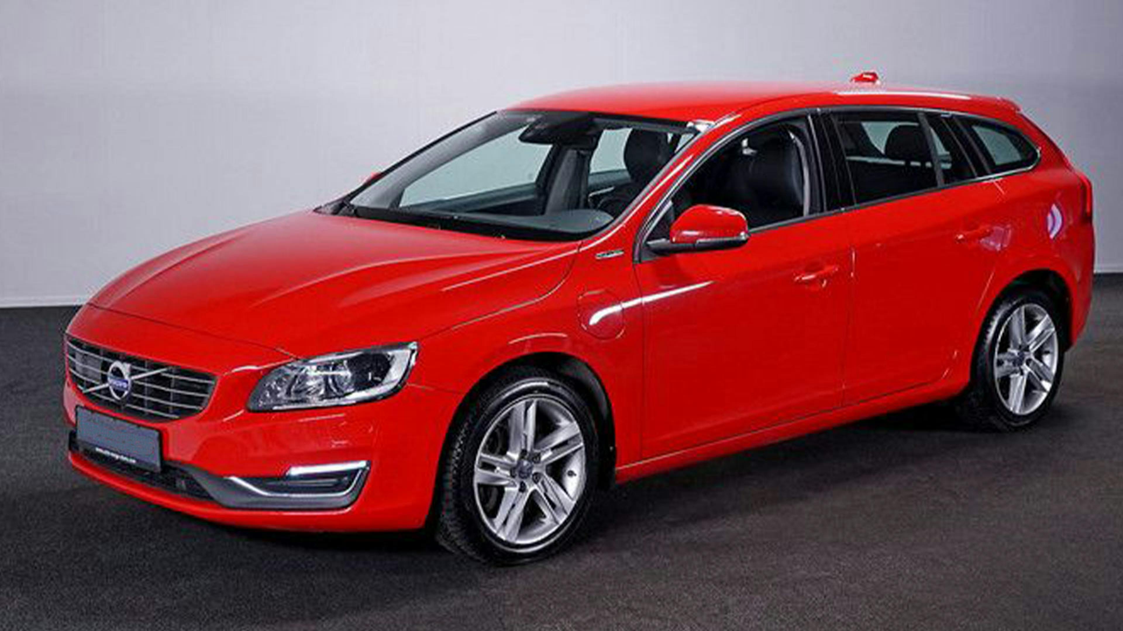 Ein roter Volvo V60 D6 Plug-in Diesel-Hybrid steht vor einer weißen Wand