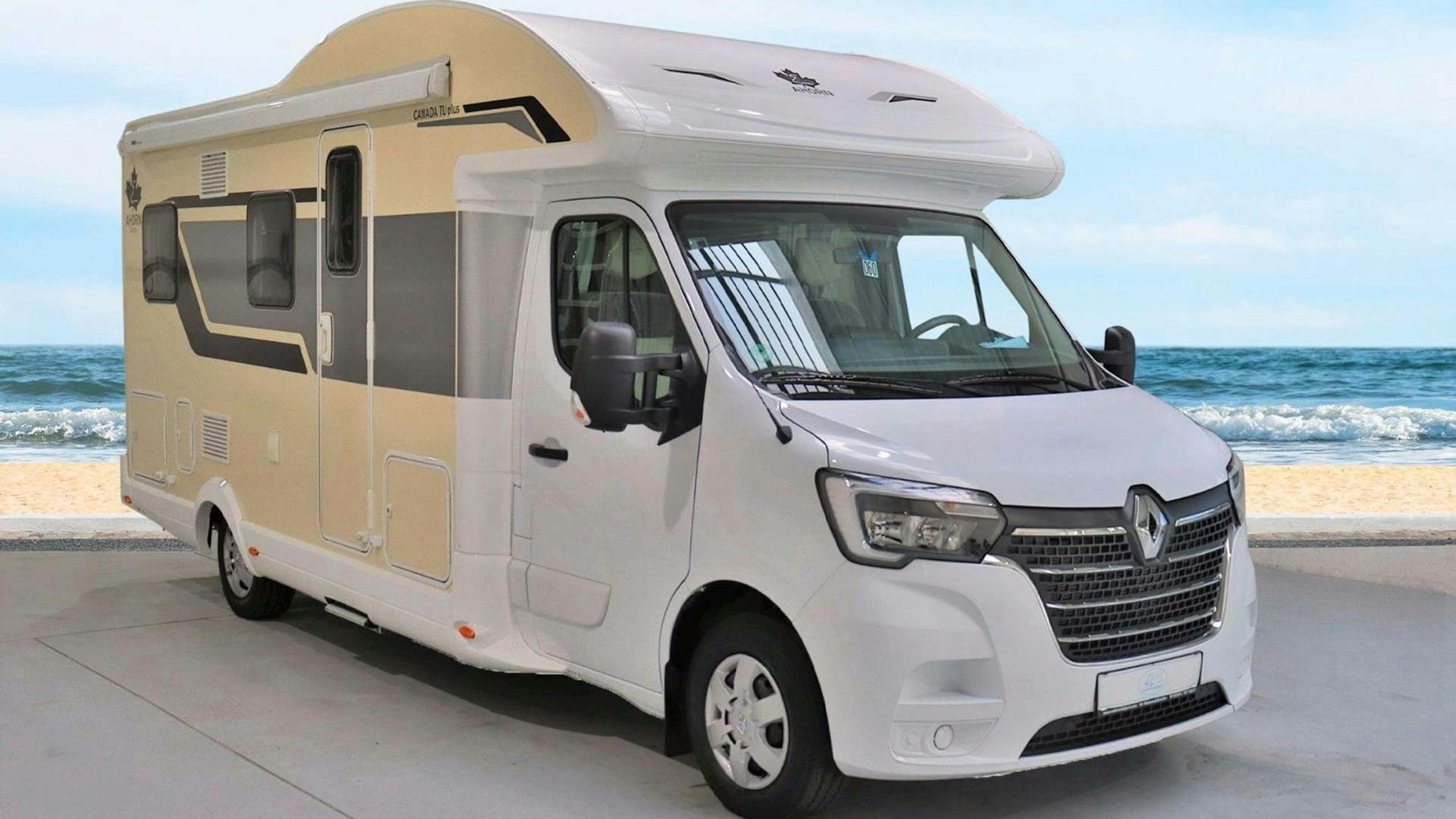 Ein Ahorn Canada Wohnmobil mit Alkoven steht an einem Strand.