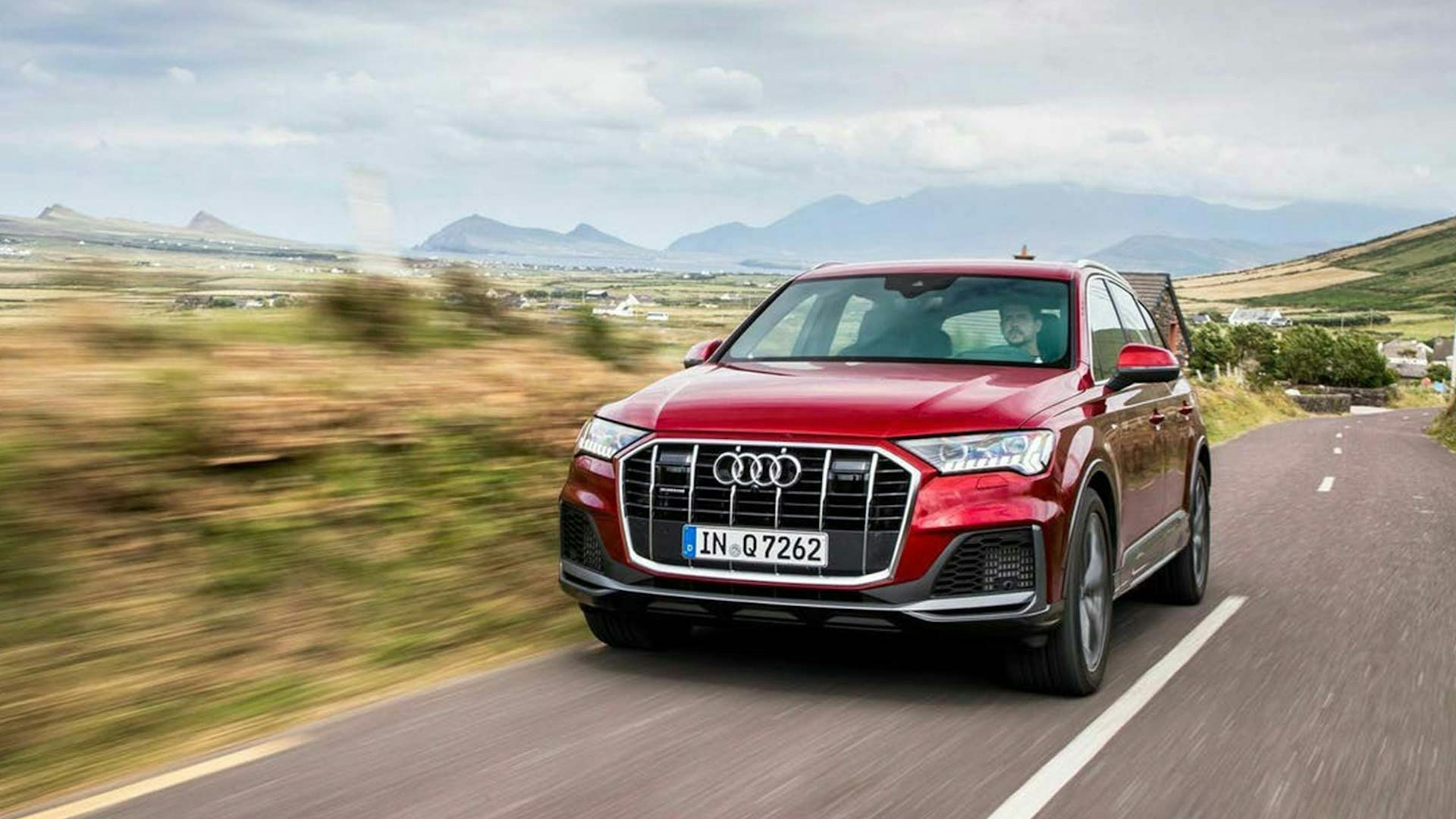 Ein roter Audi Q7 fährt eine Landstraße entlang.