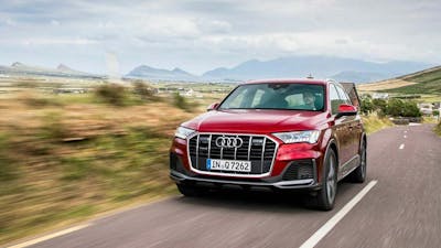 Ein roter Audi Q7 fährt eine Landstraße entlang.