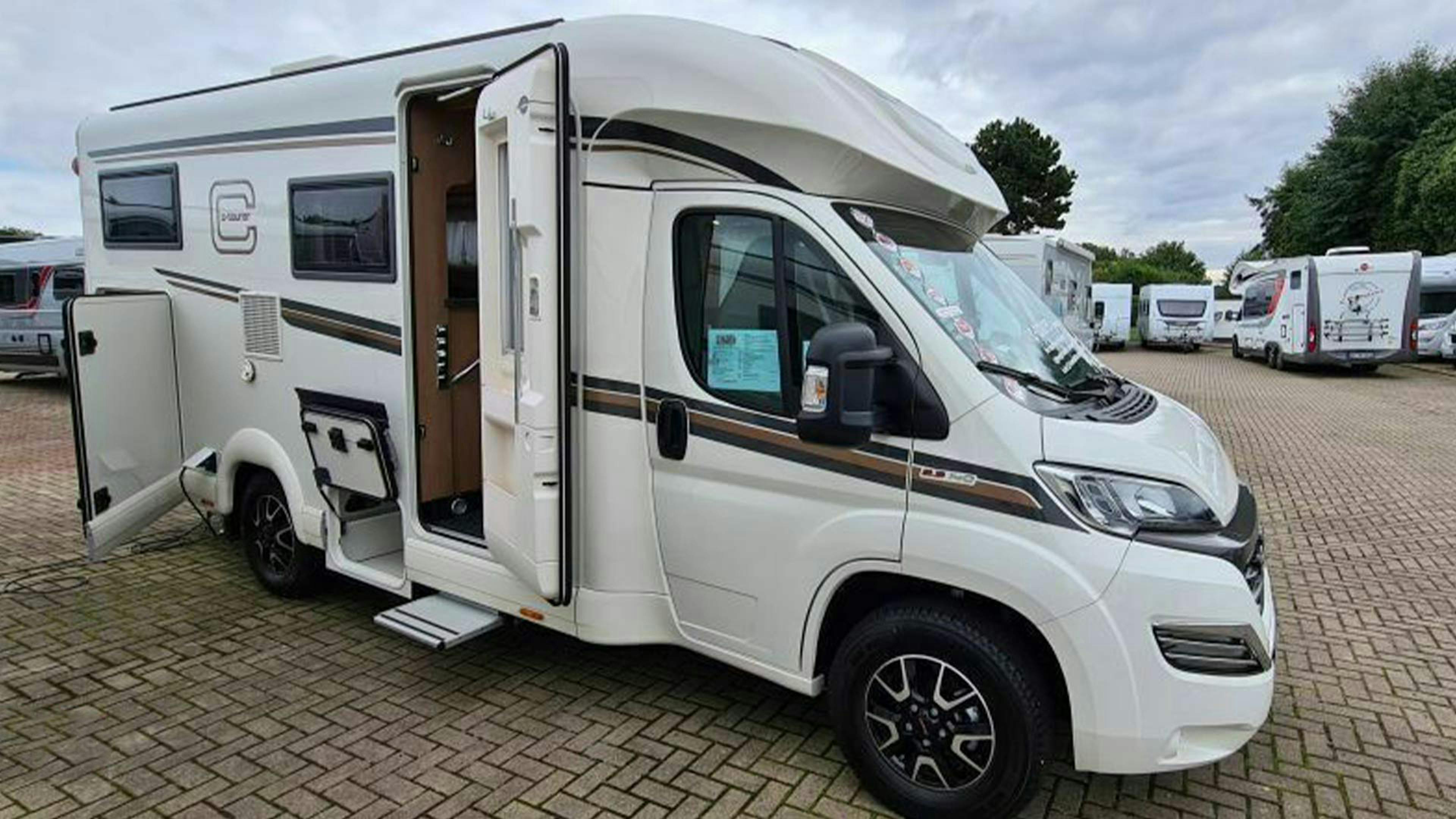 Ein teilintegriertes Wohnmobil Carthago C-Tourer T143 LE steht auf einem Parkplatz.