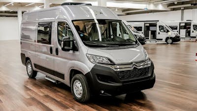 Ein günstiges Wohnmobil in Silber, der Roadcar R540, steht in einer Halle mit Holzboden