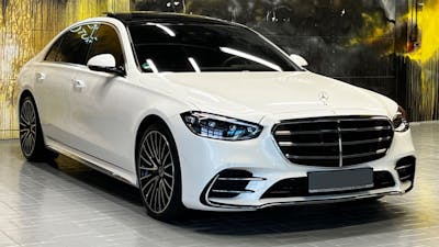 Eine weiße Mercedes-S-Klasse steht im Showroom eines Autohauses.