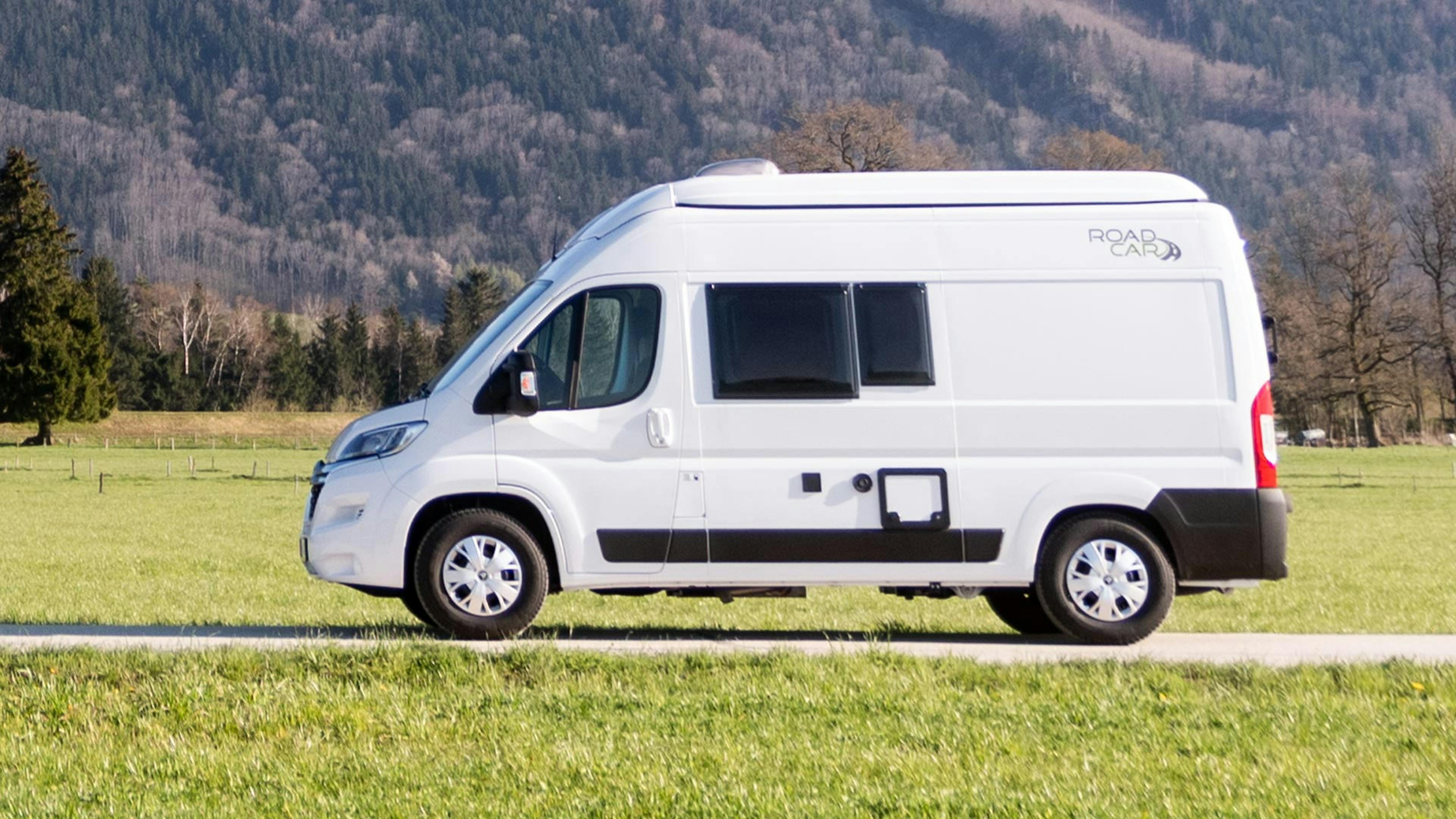 Ein weißer Roadcar R540 Campingbus parkt an einem Feldweg