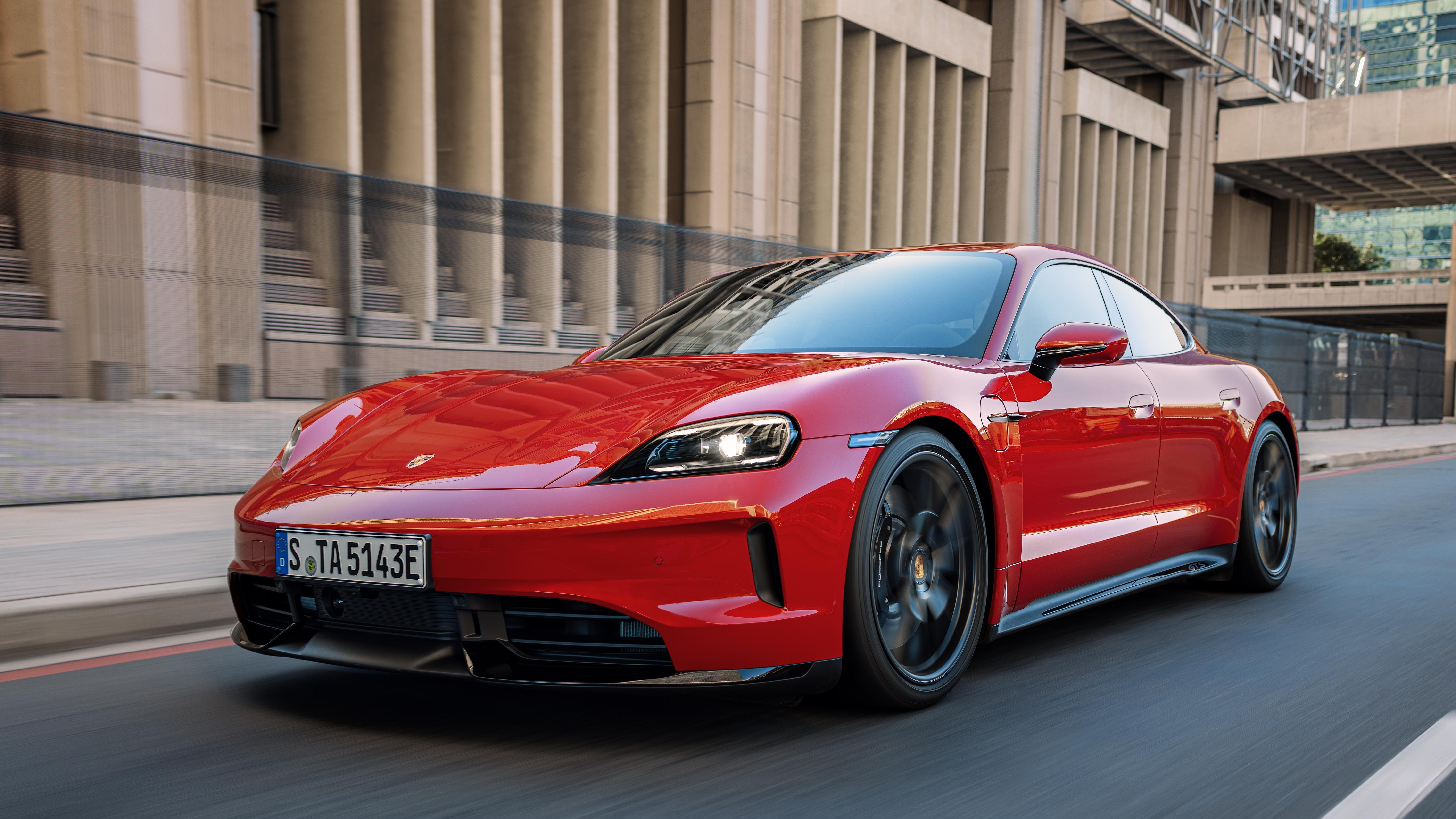 Ein roter Porsche Taycan fährt durch eine Stadt.