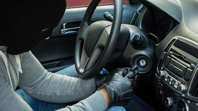 Ein Autodieb versucht, die Zündung eines Pkw ohne Autoschlüssel zu starten.