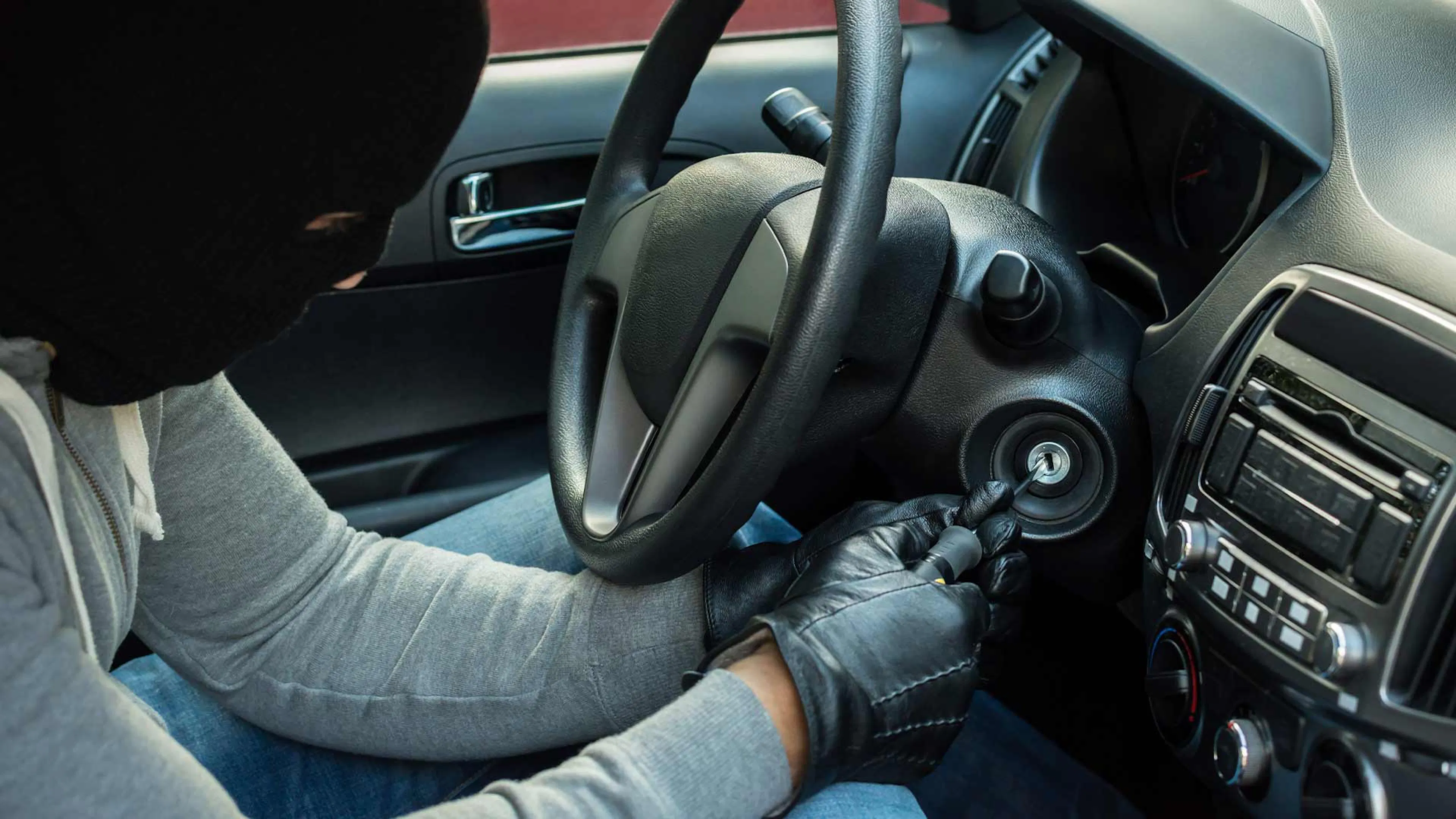 Ein Autodieb versucht, die Zündung eines Pkw ohne Autoschlüssel zu starten.
