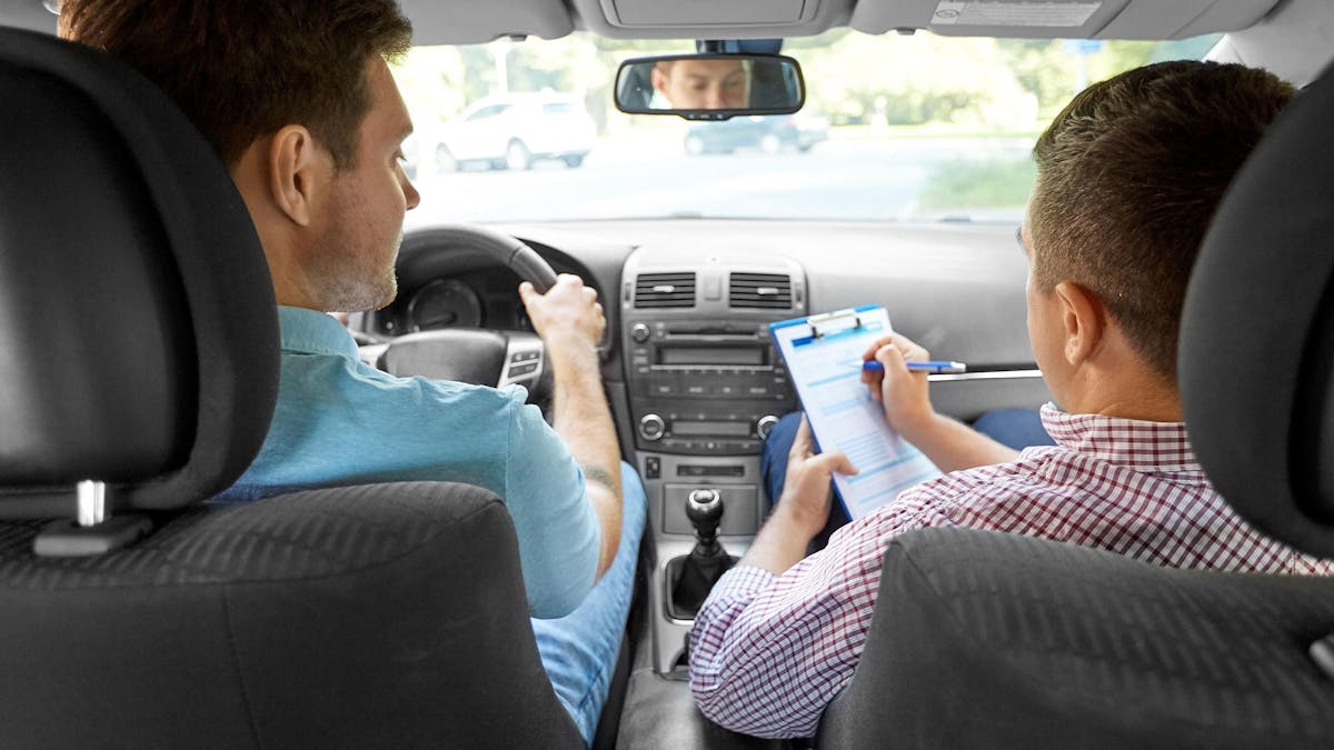 Ein Fahrschüler und ein Prüfer sitzen während einer Führerscheinprüfung in einem Pkw.