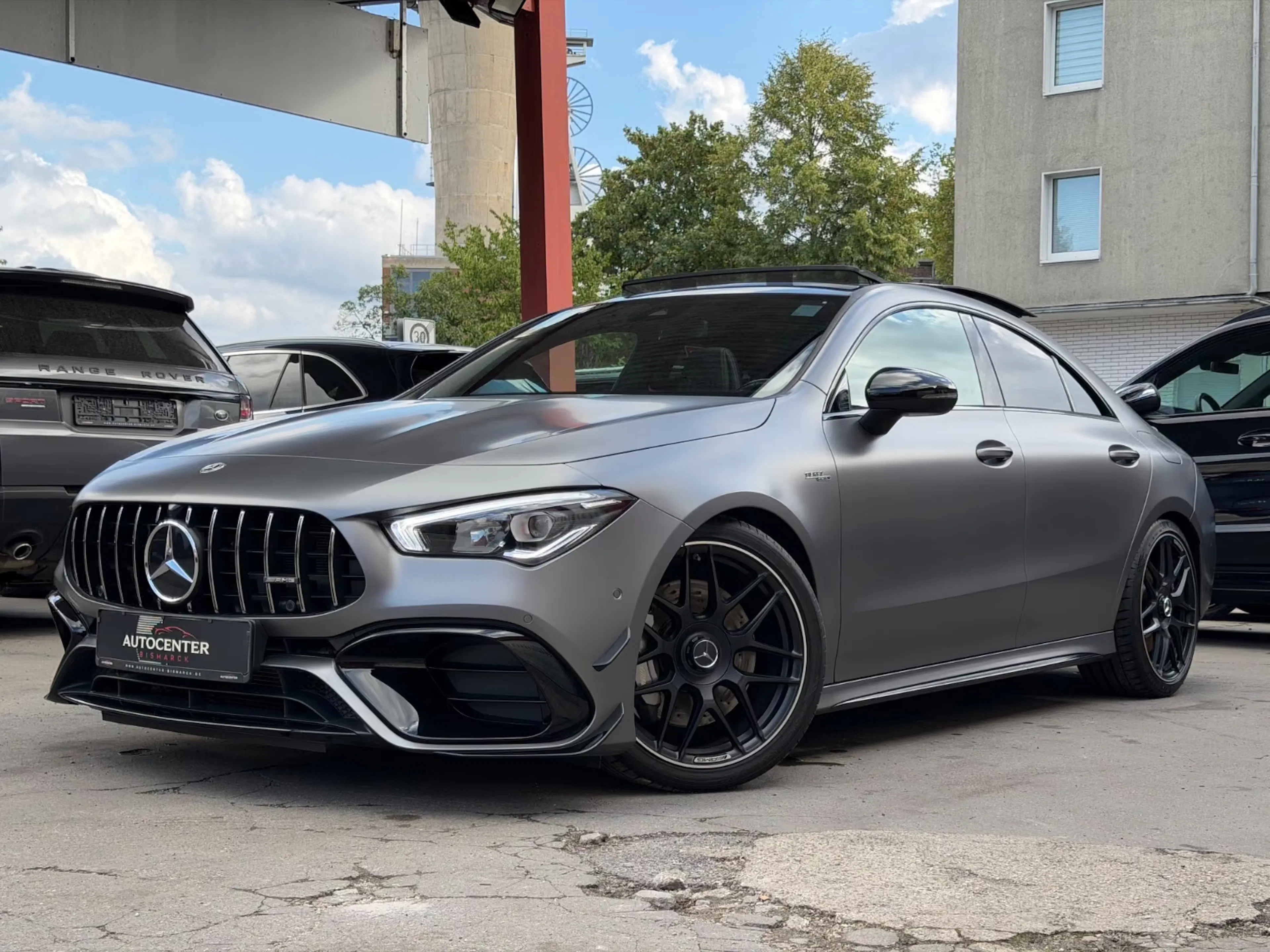 Ein Mercedes-AMG CLA 45 steht vor einem Gebäude.
