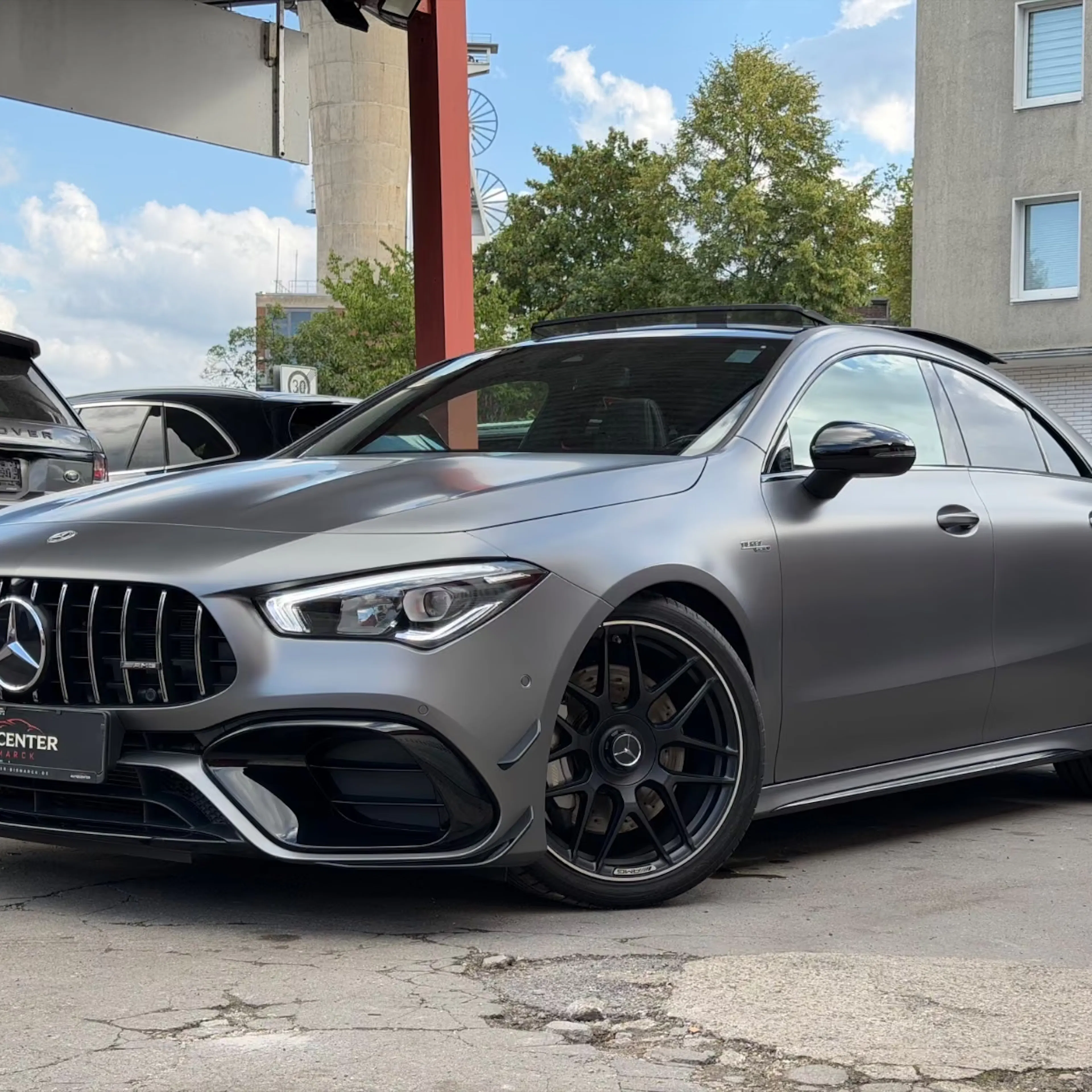 Ein Mercedes-AMG CLA 45 steht vor einem Gebäude.
