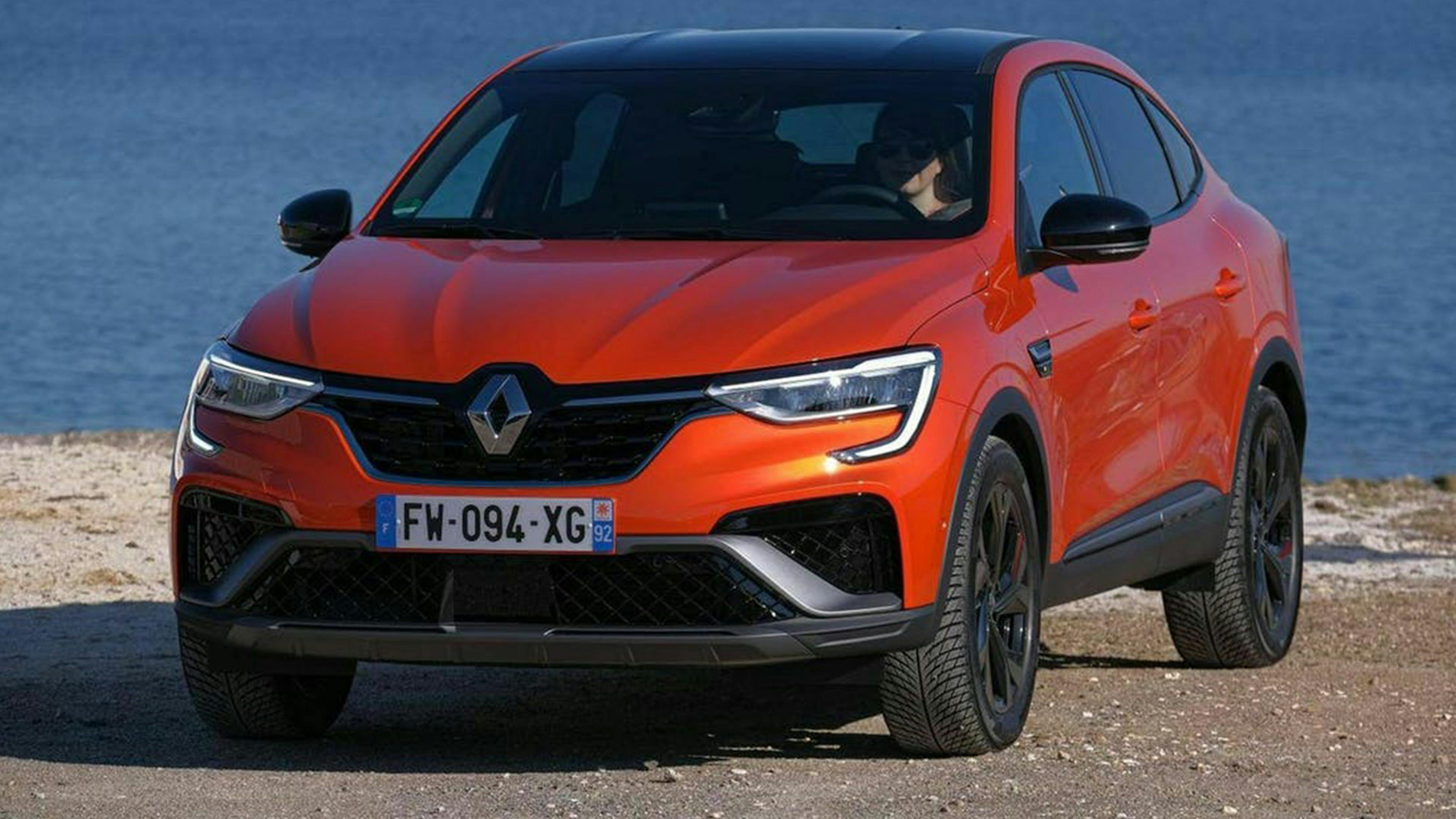 Ein roter Renault Arkana steht am Ufer eines Gewässers