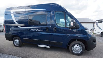 Ein dunkelblauer Pössl Summit 540 Campingbus steht auf einem Parkplatz