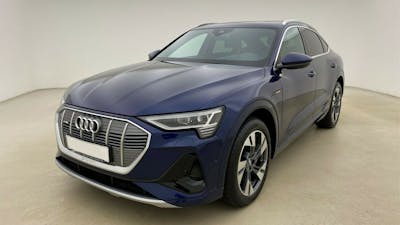 Ein dunkelblauer Audi e-tron mit Anhängerkupplung steht in einem hellen Raum