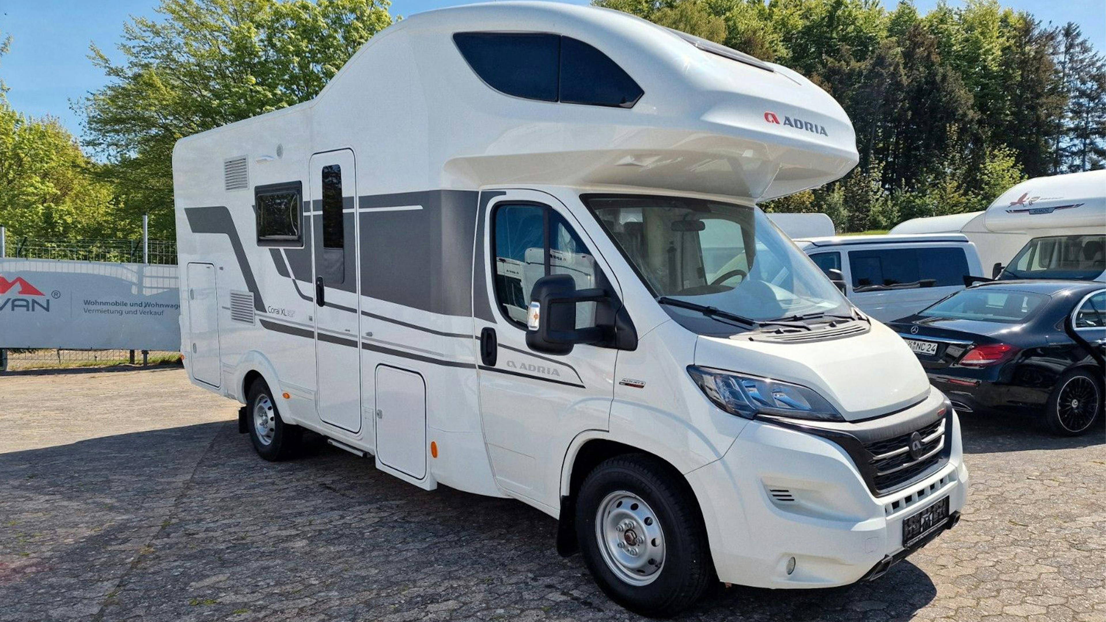 Ein Adria Coral XL Wohnmobil steht auf einem Parkplatz.