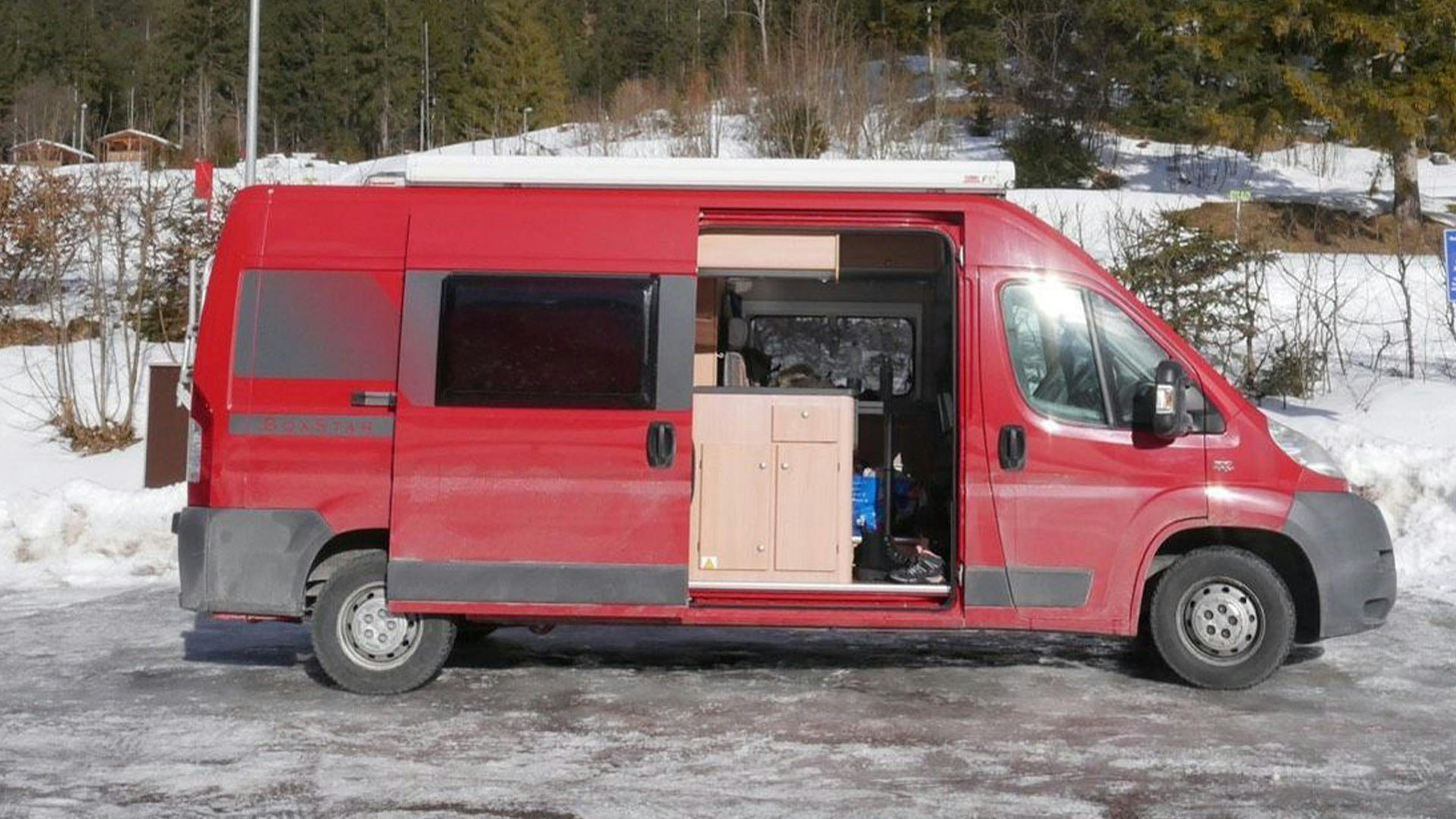 Ein rotes Knaus Boxstar Wohnmobil auf Fiat-Ducato-Basis steht auf einem Parkplatz.