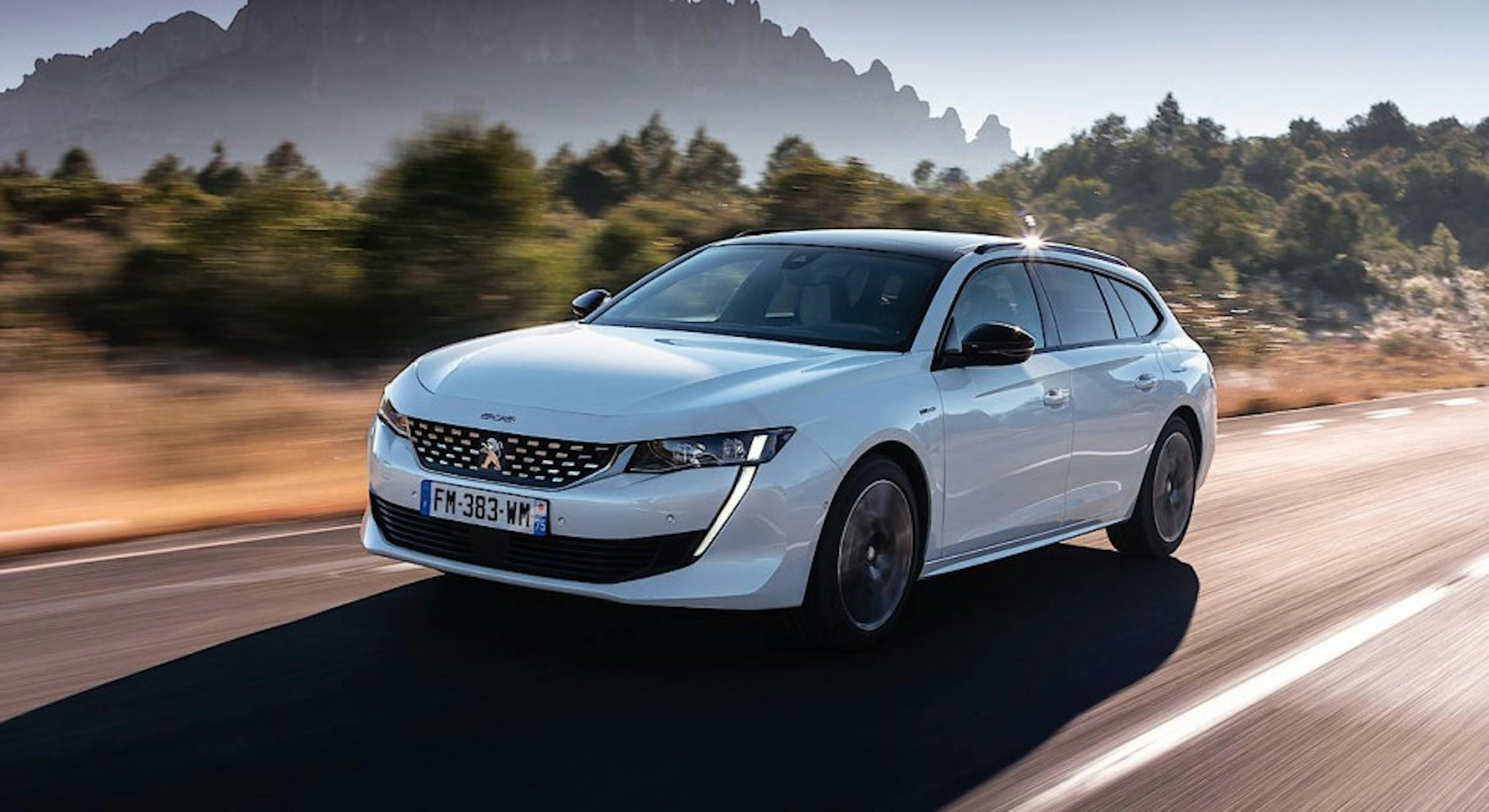 Ein weißer Peugeot 508 SW Plug-in-Hybrid fährt eine Landstraße entlang 