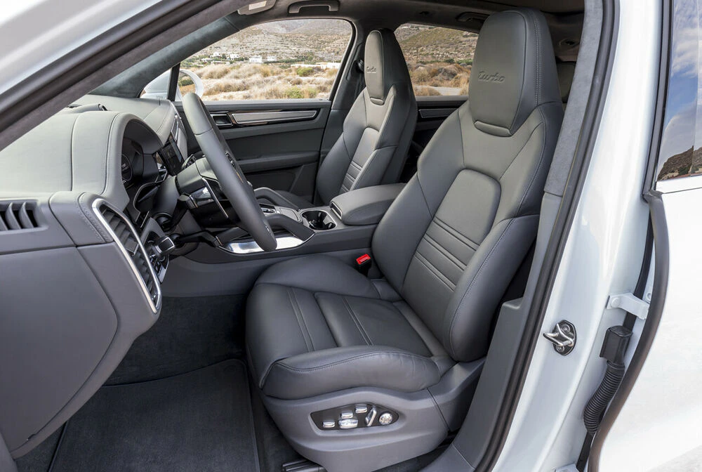 Innenraum eines modernen Autos mit schwarzen Ledersitzen, einem eleganten Armaturenbrett und einem Multifunktionslenkrad.