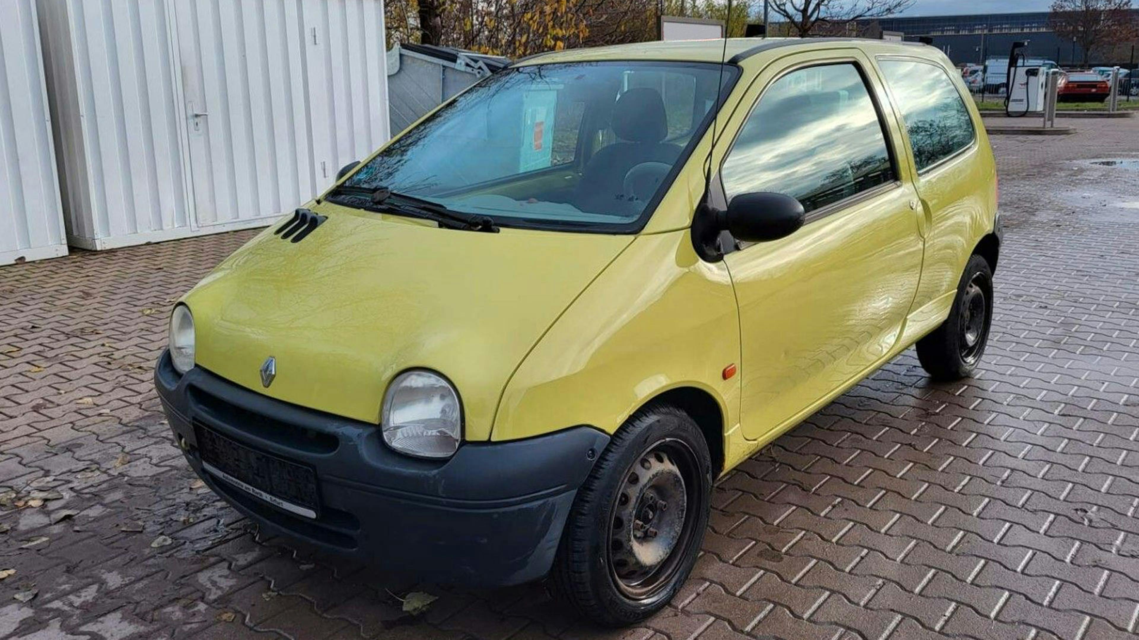 Ein gelber Renault Twingo Kleinstwagen steht auf einem Parkplatz.