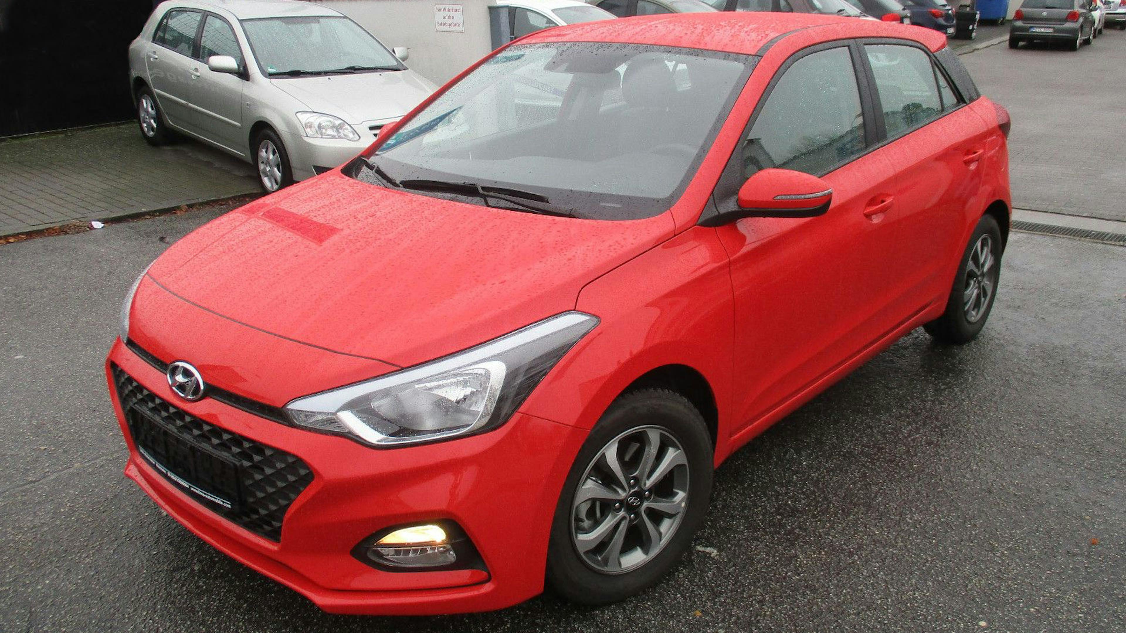 Ein roter Hyundai i20 steht auf einem Parkplatz.