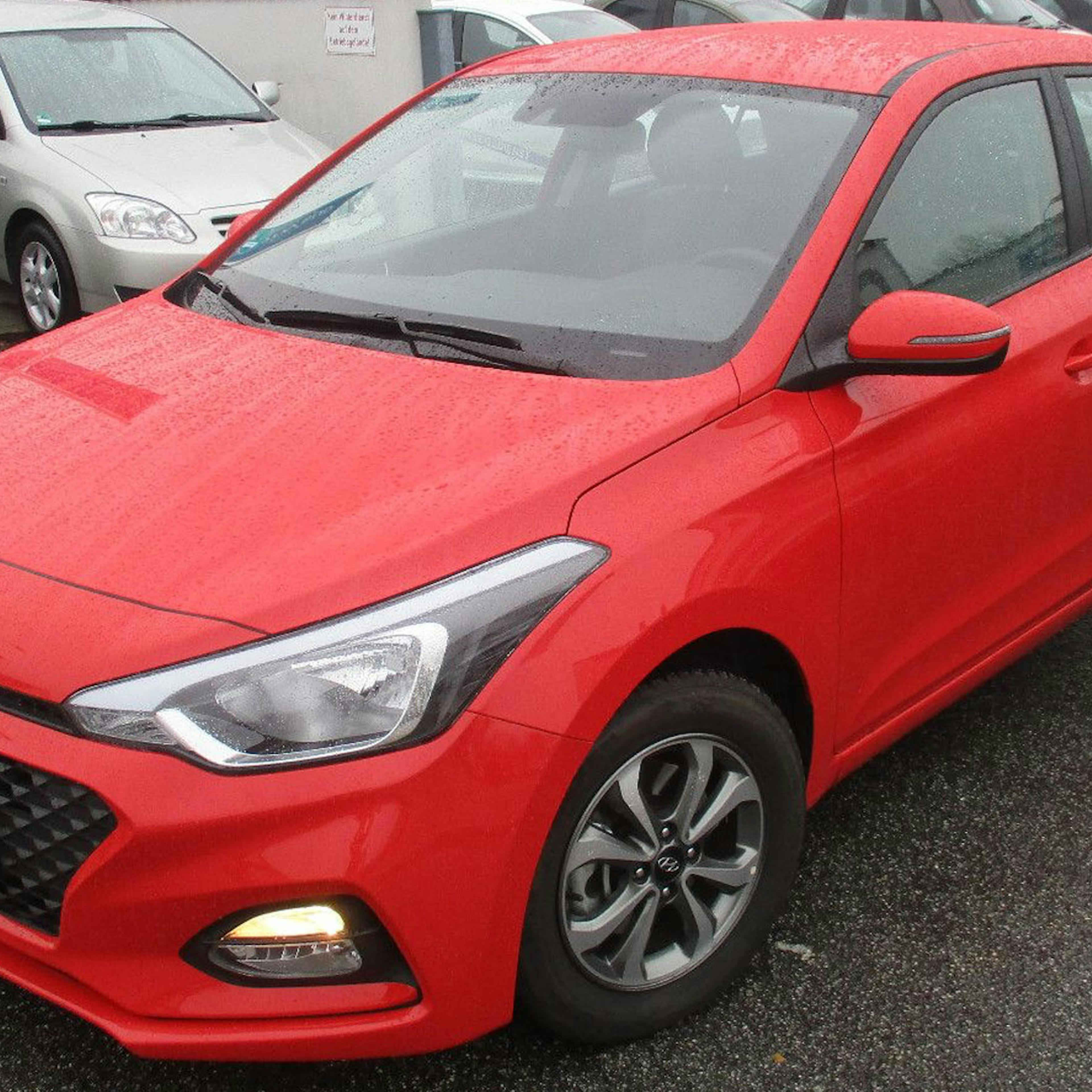  Ein roter Hyundai i20 steht auf einem Parkplatz.
