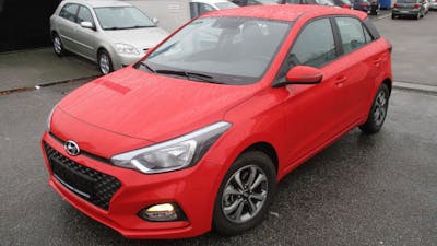 Ein roter Hyundai i20 steht auf einem Parkplatz.