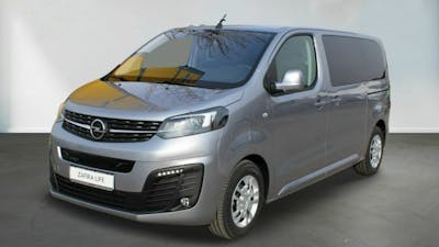 Ein silberner Opel Zafira-e Life steht vor einer weißen Wand
