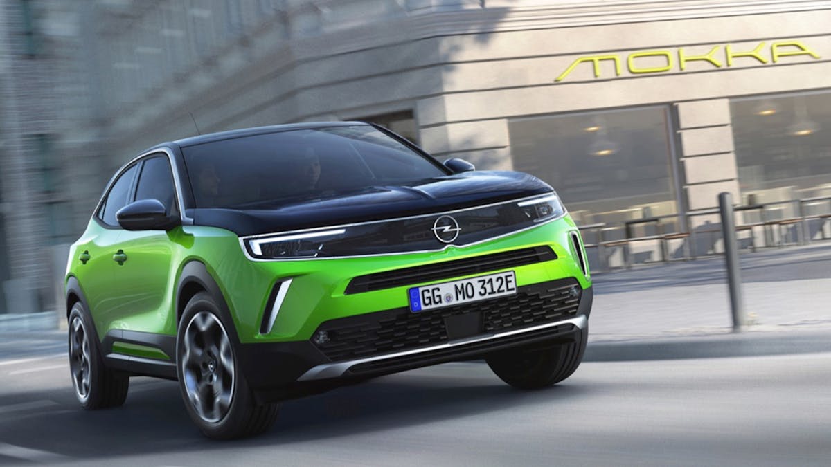 Ein grüner Opel Mokka-e fährt durch eine urbane Kulisse.